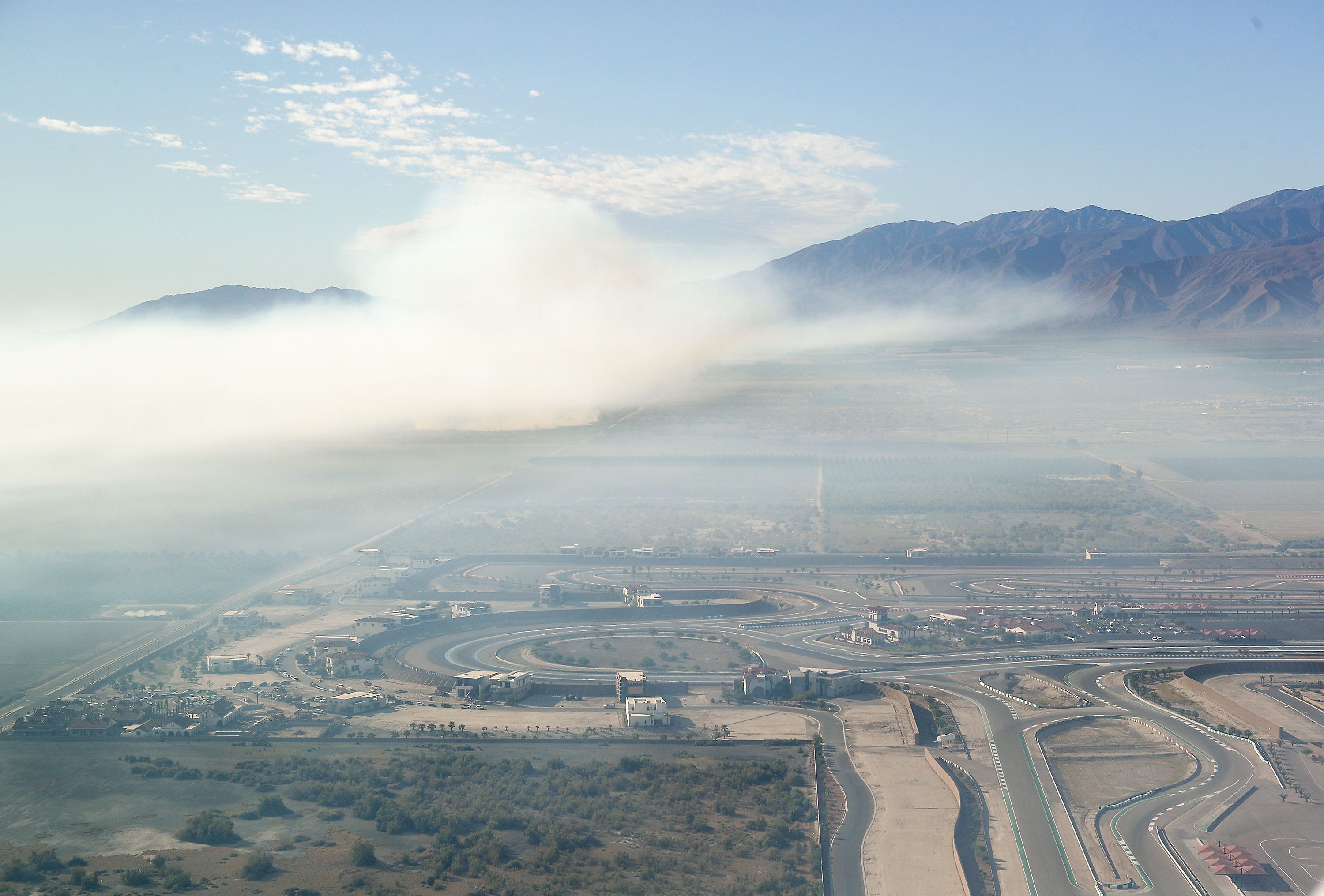Smoke from the dump fire in Thermal, Calif., pollutes the air just a short distance from The Thermal Club race track (lower right) in this aerial photo, October 17, 2019.