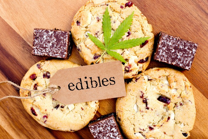A tag that says edibles and a cannabis leaf lying atop an assortment of cookies and brownies.