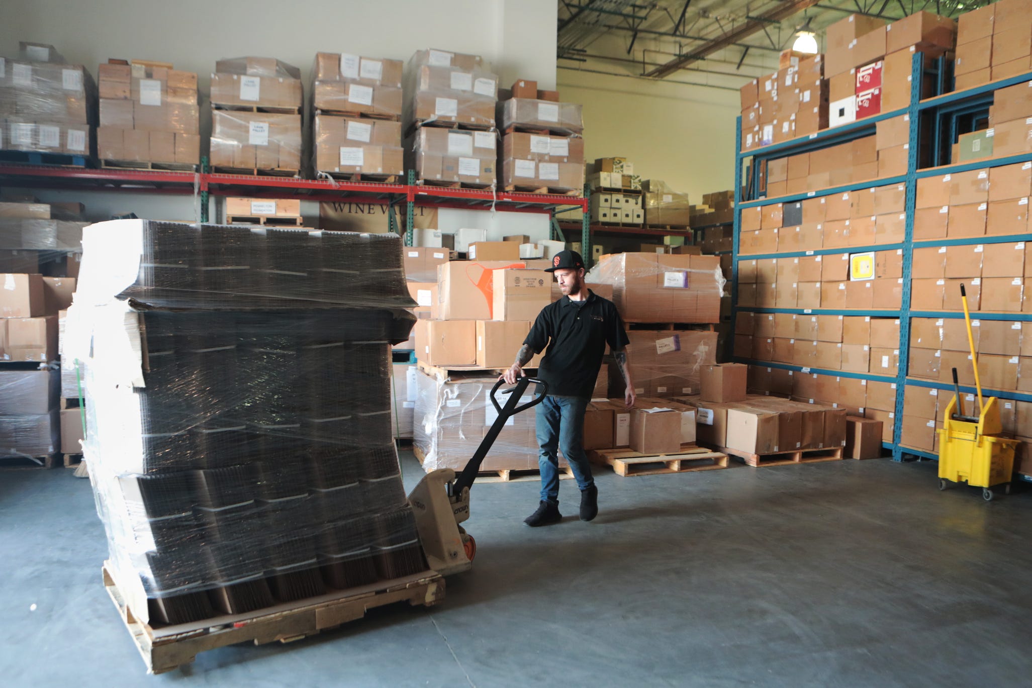 Wine Vault of the Desert employee Ryan Ferris moves boxes inside the climate controlled facility in Palm Desert, Calif., on Wednesday, October 16, 2019. 