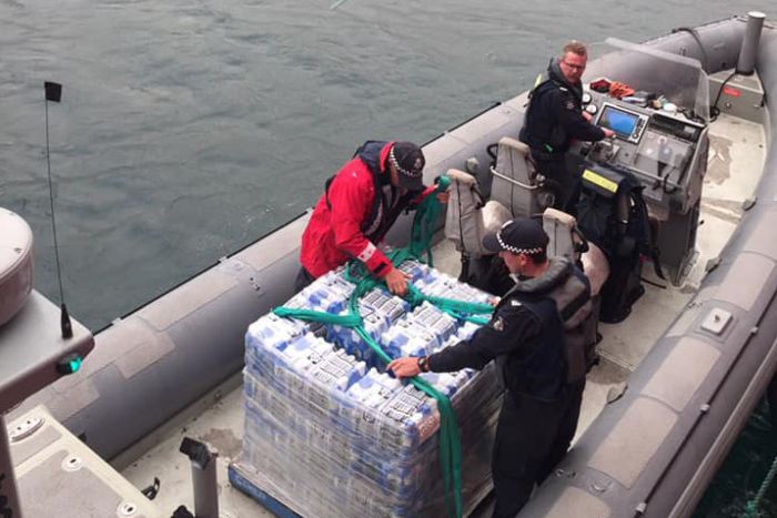 Water being delivered to Mallacoota A pallet of water is loaded onto a fisheries patrol boat.