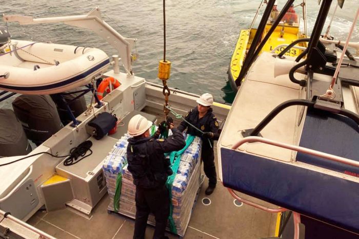 Supplies for Mallacoota Supplies being taken off the Far Saracen ship off Mallacoota onto a smaller boat.