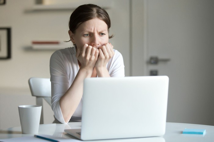 Worried woman staring at laptop computer screen 