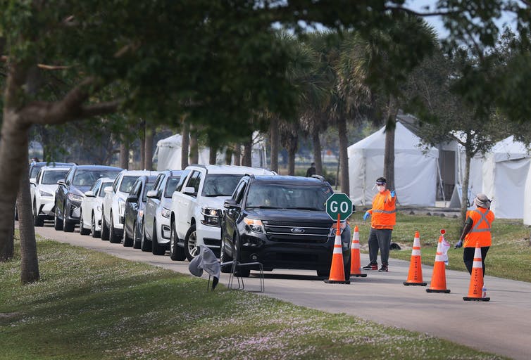 A line of cars at a drive-thru vaccination site.