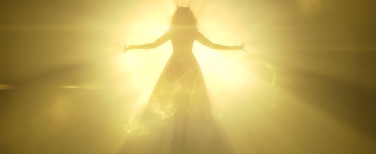 Scarlet Witch in her original costume descends from the light of the Mind Stone in WandaVision