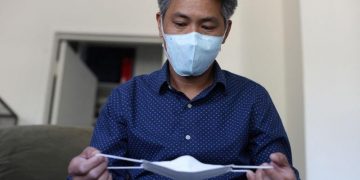 LA-based freight forwarder Tony Chen checks a kid-sized KF94 mask made in South Korea in his living room in South Pasadena – Colorado Springs Gazette